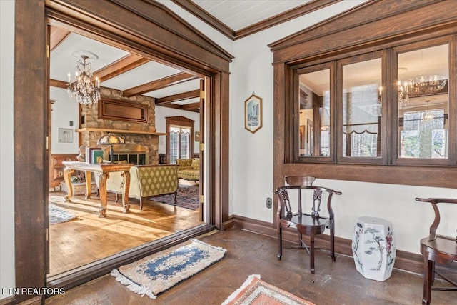 interior space featuring ornamental molding, dark wood-type flooring, beam ceiling, a fireplace, and a chandelier