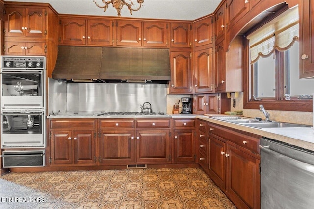 kitchen featuring a textured ceiling, sink, stainless steel appliances, and extractor fan