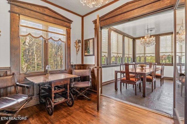 dining room featuring crown molding, an inviting chandelier, vaulted ceiling, and hardwood / wood-style flooring