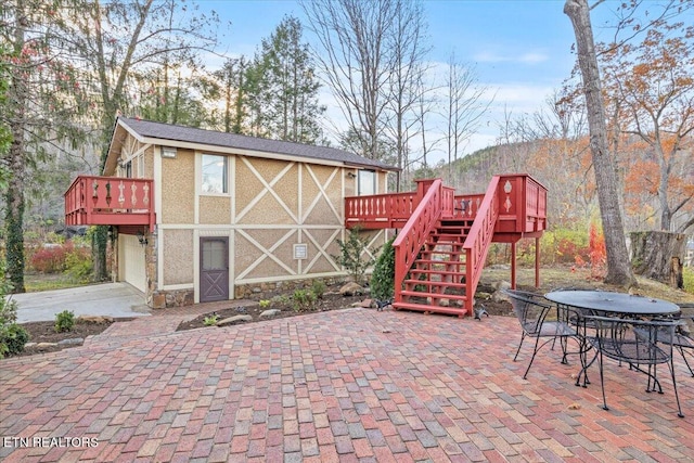 view of patio / terrace with a garage and a deck with mountain view