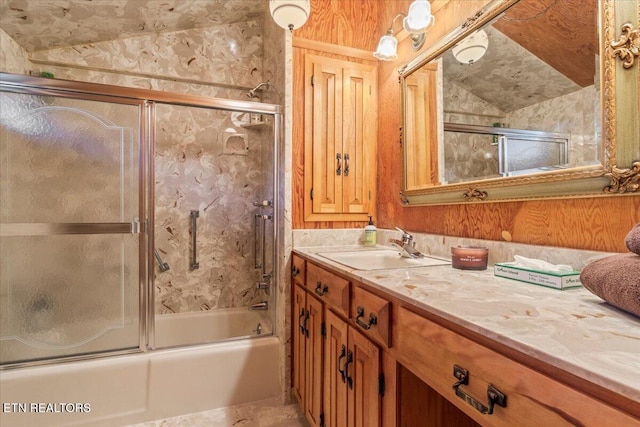 bathroom featuring shower / bath combination with glass door, vanity, and vaulted ceiling