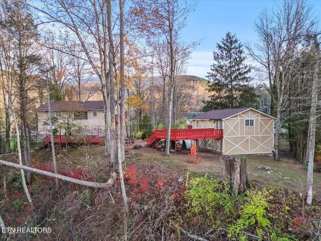 view of yard with an outbuilding and a deck with mountain view