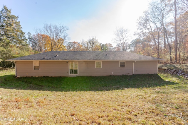 rear view of property featuring a lawn