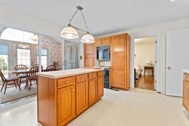 kitchen featuring light carpet, a textured ceiling, range, a center island, and hanging light fixtures