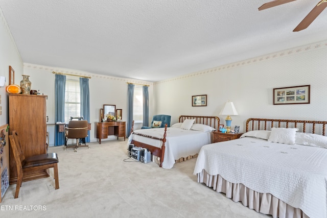 bedroom with ceiling fan, light colored carpet, and a textured ceiling