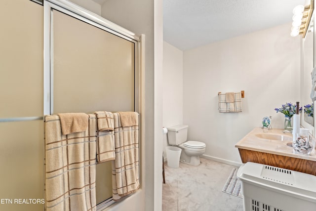 bathroom featuring a textured ceiling, vanity, toilet, and a shower with shower door