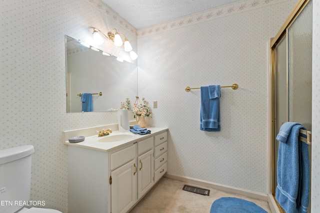 bathroom with an enclosed shower, vanity, toilet, and a textured ceiling