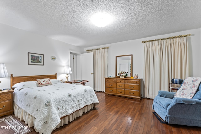 bedroom featuring a textured ceiling and dark hardwood / wood-style flooring