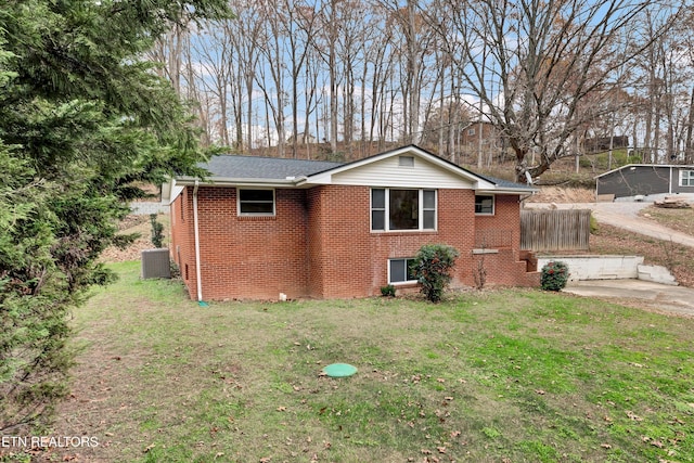 view of side of property featuring a yard and central AC unit