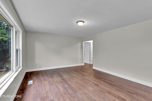 spare room featuring dark hardwood / wood-style floors and plenty of natural light