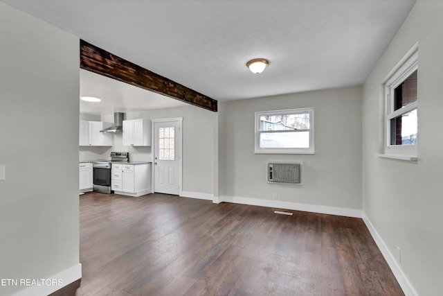 unfurnished living room with beamed ceiling, dark hardwood / wood-style floors, and heating unit