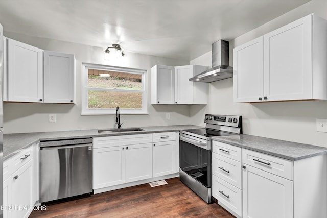 kitchen featuring white cabinets, dark hardwood / wood-style floors, wall chimney range hood, and appliances with stainless steel finishes