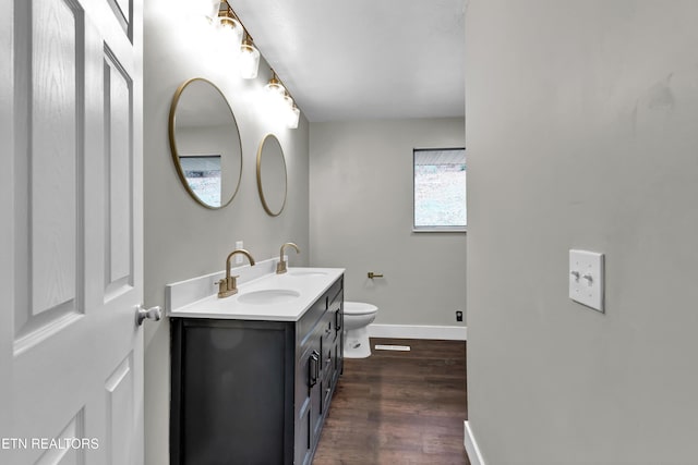 bathroom with toilet, vanity, and hardwood / wood-style flooring