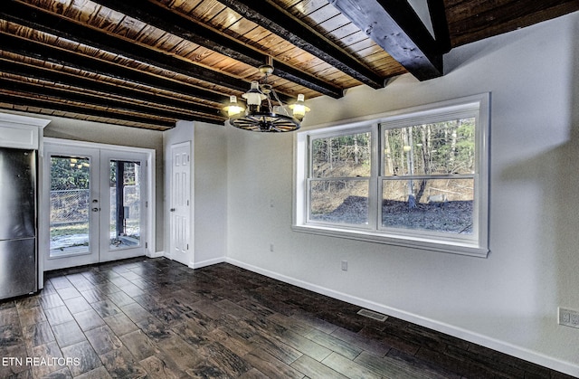 unfurnished dining area with a notable chandelier, wood ceiling, french doors, and beamed ceiling