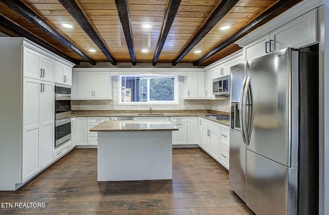 kitchen with stainless steel appliances, sink, light stone counters, a kitchen island, and wood ceiling