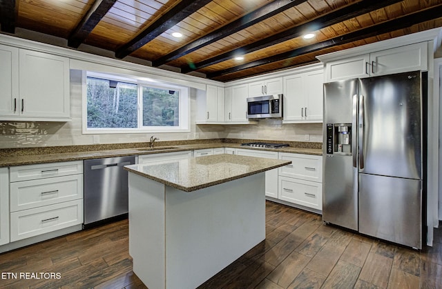 kitchen featuring wooden ceiling, appliances with stainless steel finishes, a center island, light stone countertops, and white cabinetry