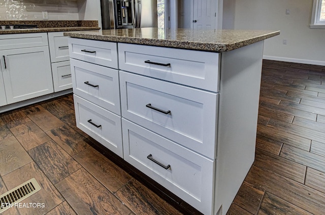 kitchen featuring appliances with stainless steel finishes, white cabinetry, and a center island