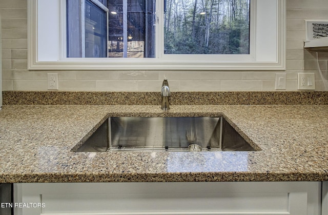 interior details featuring decorative backsplash and sink