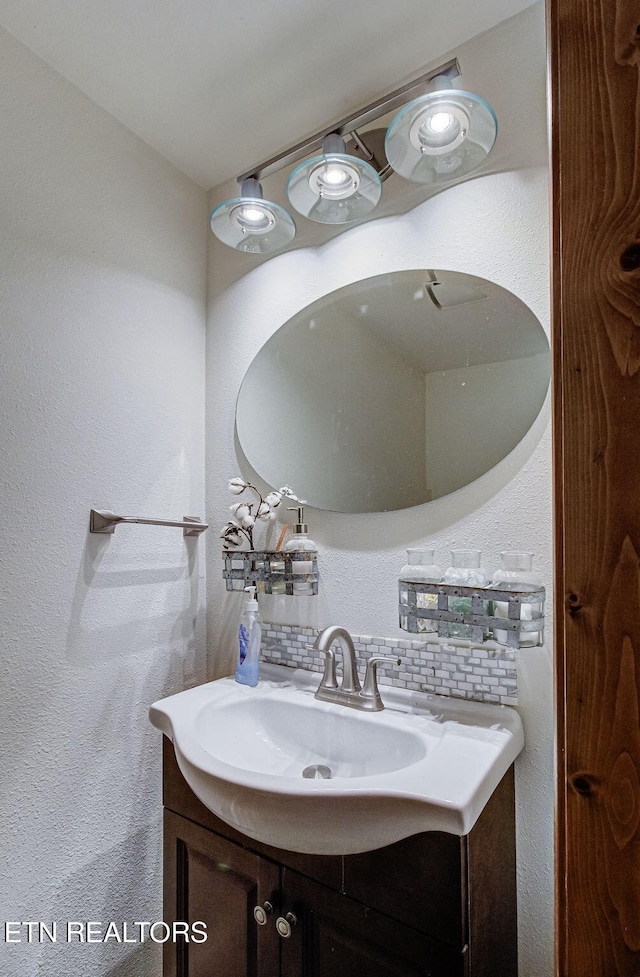 bathroom featuring vanity and decorative backsplash