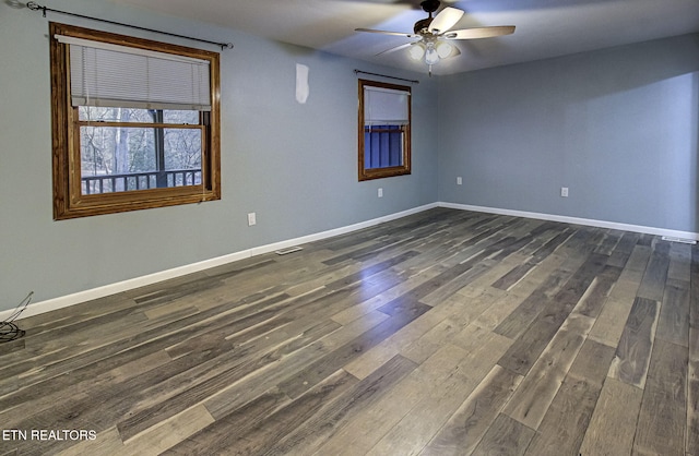 spare room with ceiling fan and dark wood-type flooring