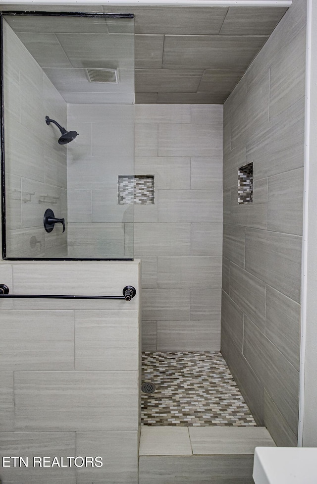 bathroom with a tile shower