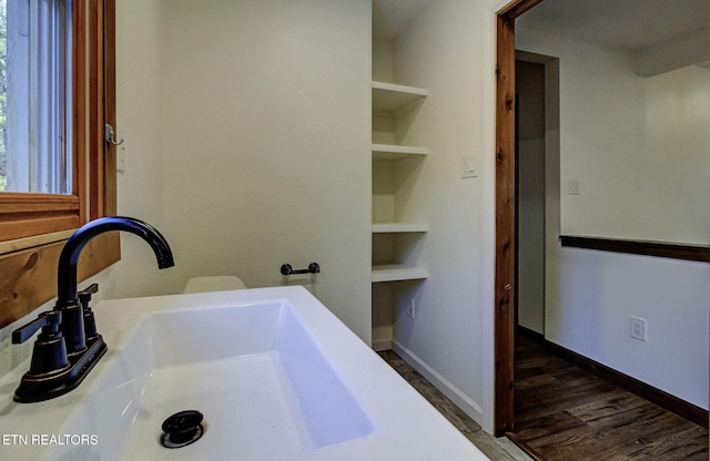 bathroom featuring sink, hardwood / wood-style floors, and built in features