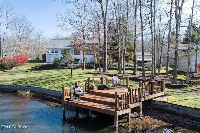 view of dock with a yard and a deck with water view