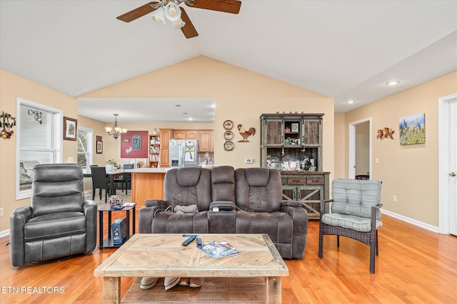 living room featuring ceiling fan with notable chandelier, light wood-type flooring, and lofted ceiling