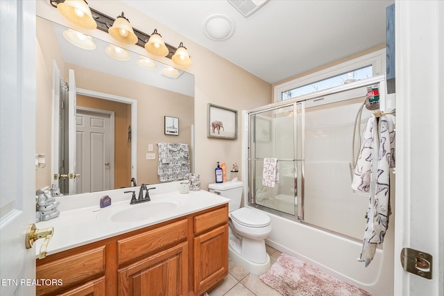 full bathroom with tile patterned floors, vanity, toilet, and bath / shower combo with glass door