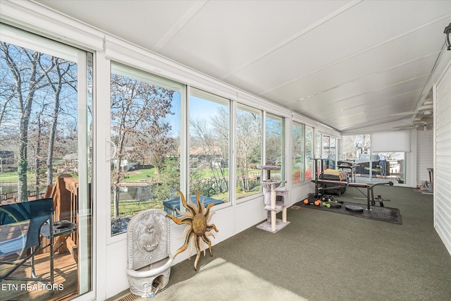 sunroom / solarium with a water view, vaulted ceiling, and ceiling fan