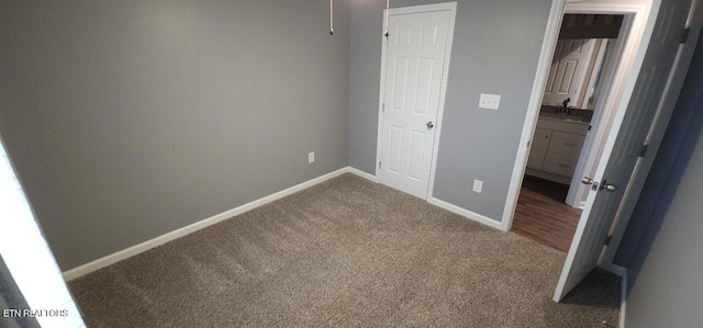 unfurnished bedroom with sink and carpet