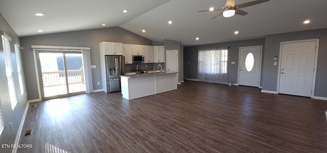 kitchen featuring appliances with stainless steel finishes, a kitchen island with sink, dark hardwood / wood-style floors, white cabinetry, and lofted ceiling