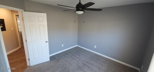 unfurnished bedroom featuring ceiling fan and dark carpet