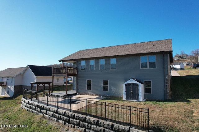 rear view of house featuring a storage shed, a lawn, a patio, and a balcony