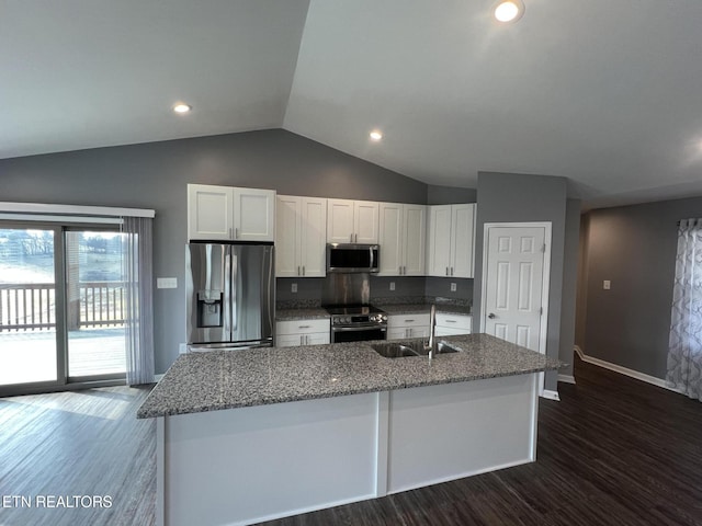 kitchen with sink, white cabinetry, appliances with stainless steel finishes, stone counters, and a kitchen island with sink