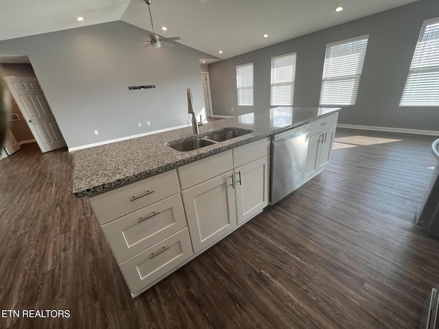 kitchen featuring dark hardwood / wood-style floors, dishwasher, white cabinets, light stone counters, and a center island with sink