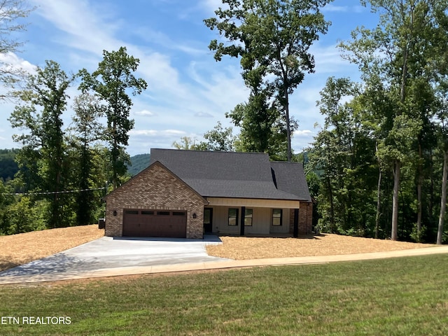 view of front of property featuring a front yard and a garage