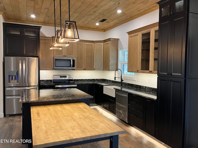 kitchen with appliances with stainless steel finishes, wood-type flooring, wooden ceiling, a center island, and hanging light fixtures