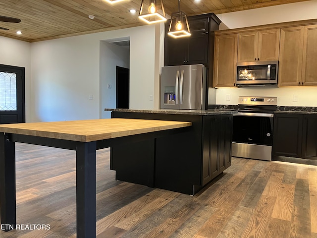 kitchen with appliances with stainless steel finishes, hardwood / wood-style flooring, wooden ceiling, butcher block countertops, and a kitchen island