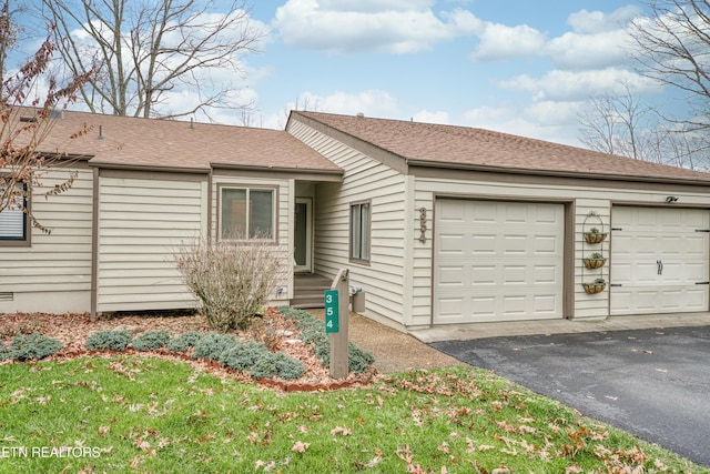 single story home featuring a front yard and a garage