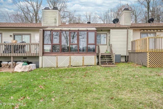 back of house featuring a lawn, a sunroom, cooling unit, and a deck