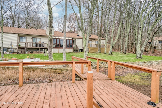 deck with a yard and a sunroom