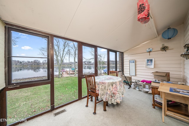 sunroom featuring a water view and lofted ceiling