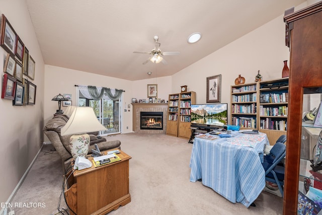 living room featuring ceiling fan, a fireplace, light colored carpet, and vaulted ceiling