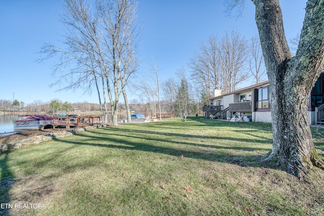 view of yard with a deck with water view