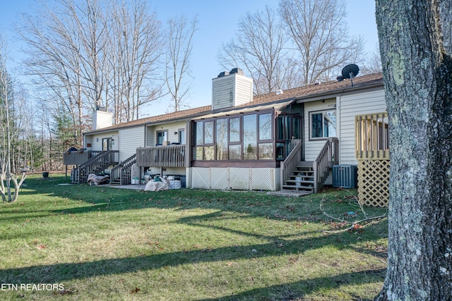 back of house featuring central AC, a lawn, and a sunroom