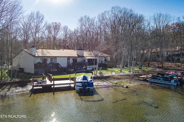 view of dock featuring a lawn and a deck with water view