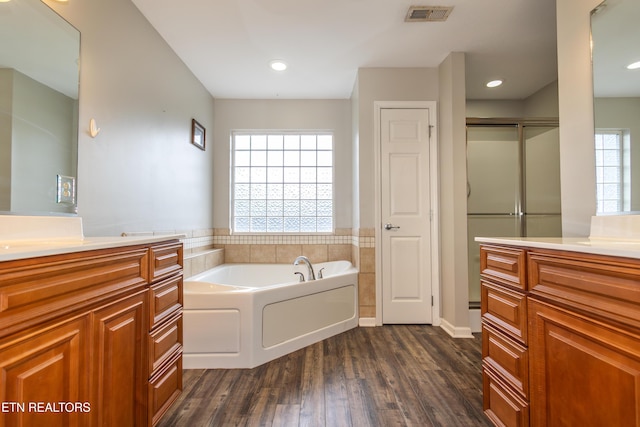 bathroom featuring hardwood / wood-style floors, vanity, and shower with separate bathtub