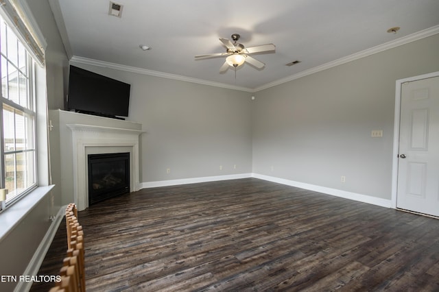 unfurnished living room featuring crown molding, ceiling fan, dark hardwood / wood-style flooring, and a healthy amount of sunlight