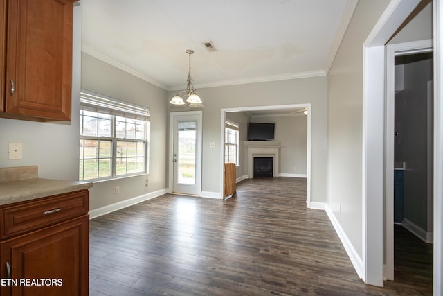 unfurnished dining area with crown molding, dark hardwood / wood-style floors, and an inviting chandelier